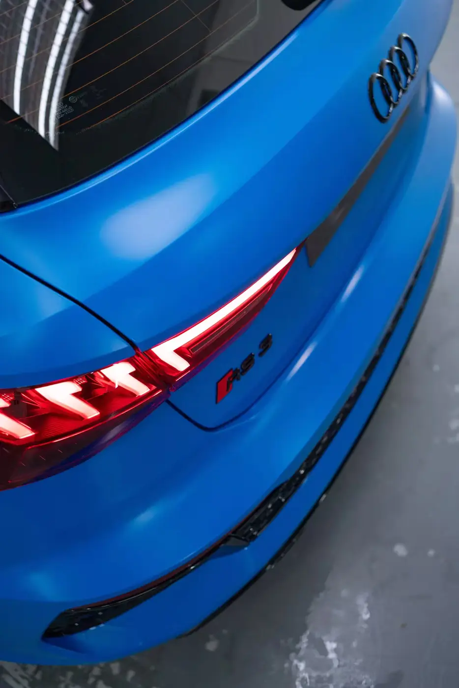 Satin mavi spor otomobilin arka ve stop lambası detayı